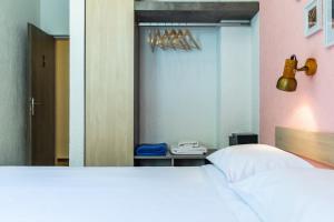 a bedroom with a white bed and a mirror at Panormos Beach Hotel Skopelos in Panormos Skopelos