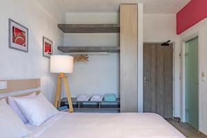 a bedroom with a bed and a table with a lamp at Panormos Beach Hotel Skopelos in Panormos Skopelos