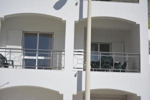a building with a balcony with a table and chairs at Apartamento Azul in Quarteira