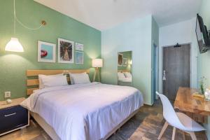 a bedroom with a large bed and a desk at Panormos Beach Hotel Skopelos in Panormos Skopelos