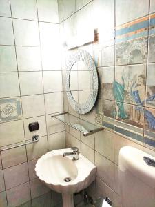 W białej łazience znajduje się umywalka i lustro. w obiekcie Anastasiou Home in central crossroad w mieście Perdika