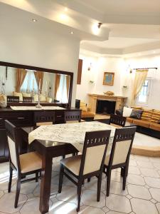 - un salon avec une table, des chaises et un canapé dans l'établissement Anastasiou Home in central crossroad, à Perdika