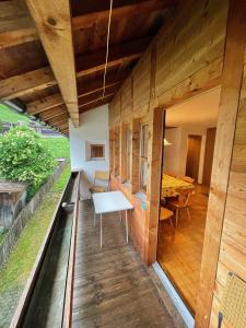 Cette maison en bois dispose d'un balcon avec une table. dans l'établissement Gasthaus Beverin, à Fardün