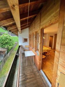 a wooden house with a balcony with a table at Gasthaus Beverin in Fardün