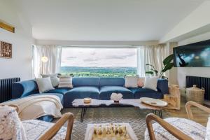 sala de estar con sofá azul y ventana grande en Bryniau Isaf en Dyserth