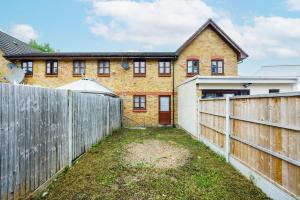 a fence in front of a brick house at Lovely 2 Bd Hse with Parking near Excel in London