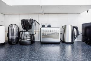 a group of appliances on a counter in a kitchen at Lovely 2 Bd Hse with Parking near Excel in London