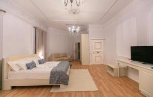 a bedroom with a bed and a desk with a television at Vila Ferdinand Modern Rooms In Tirana's Center in Tirana