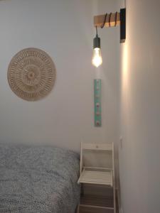a bedroom with a bed and a light on the wall at Ferragood House - Historic Center in Ferragudo