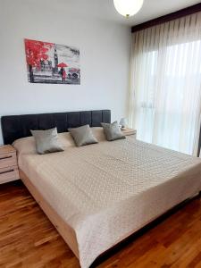 a bedroom with a large bed with white sheets at Apartman Peregrinus in Korenica