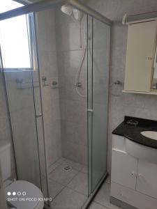 a shower with a glass door in a bathroom at Apartamento da Fô in Pelotas