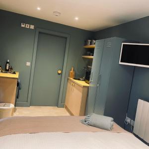 a bedroom with a bed and a tv on the wall at Studio 22 in Harrogate