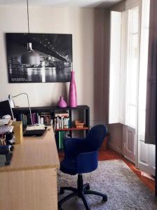 Habitación con escritorio y silla azul. en Acogedor apartamento en el Casco Antiguo, en Vigo