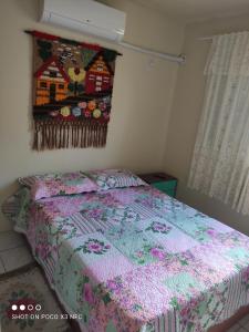 a bedroom with a bed with a quilt on it at Apartamento da Fô in Pelotas