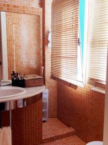 ein Bad mit einem Waschbecken und einer Dusche mit einem Fenster in der Unterkunft Acogedor apartamento en el Casco Antiguo in Vigo