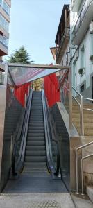 a set of stairs leading up to a red wall at Acogedor apartamento en el Casco Antiguo in Vigo