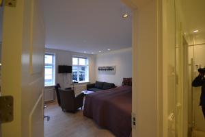 a bedroom with a bed and a couch and a window at Next Apartment Bergstadastræti in Reykjavík