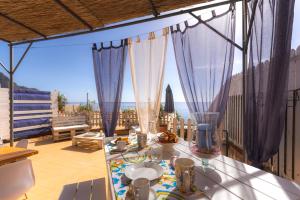 a table on a balcony with a view of the ocean at Dimore di mare - Beachfront Apartments in Santa Flavia