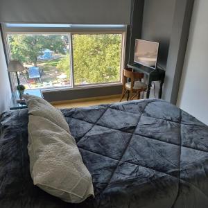 una camera con un letto e una finestra e un pianoforte di Departamento Céntrico, peatonal, vistas a la Plaza a Corrientes