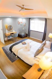彼得馬里茨堡的住宿－Mdumela Stays 2 Bedroom Modern City Apartment，一张大白色的床,位于带书桌的房间里