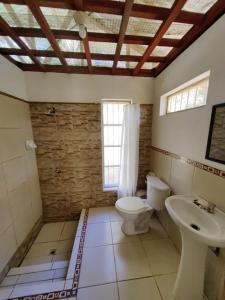 a bathroom with a toilet and a sink at Albertico Jungle House in Pucallpa