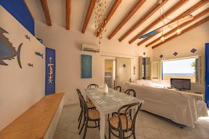 a living room with a table and chairs and a bed at Dimore di mare - Beachfront Apartments in Santa Flavia