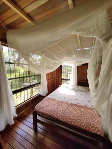 ein Schlafzimmer mit einem Himmelbett und einem Fenster in der Unterkunft Albertico Jungle House in Pucallpa