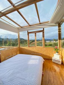 1 dormitorio con 1 cama grande en una habitación con ventanas en Killary Lodge, en Cachanlo de Sidcay
