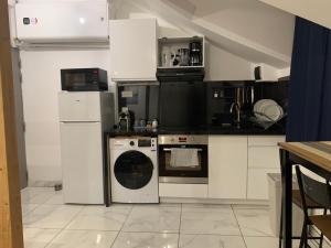 a kitchen with a stove and a dishwasher at Appartement - Proche CDG - Paris & Stade de France in Aubervilliers