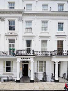 ein weißes Gebäude mit einer schwarzen Tür und einem Balkon in der Unterkunft Glendale Hyde Park Hotel in London