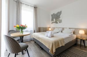 a bedroom with a bed and a table with a vase of flowers at Karkonoskie Widoki in Karpacz +54 photos