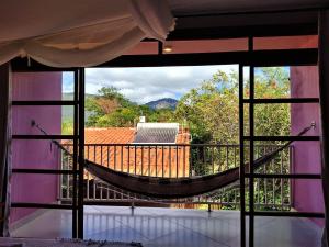 a room with a hammock on a balcony at Pousada Zazen in Vale do Capao