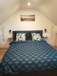 a bedroom with a large blue bed with pillows at Le Figuier - Paris Gare du Nord en 15 min - in Deuil-la-Barre