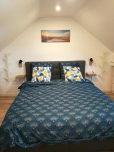 a bedroom with a large blue bed with pillows at Promotion du Jour - Le Figuier in Deuil-la-Barre