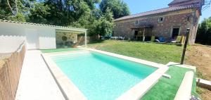 a swimming pool in a yard next to a house at Maison de charme in Pont-du-Casse