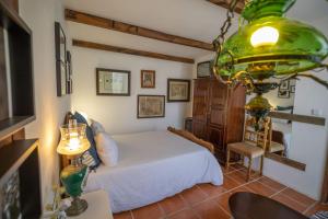 a bedroom with a white bed and a green chandelier at Beach House Babylon guest house with kitchenette and garden in Torreira