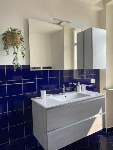 baño con lavabo blanco y azulejos azules en Il Giardino Segreto, en Biella