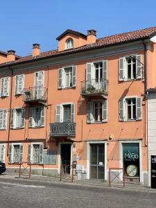 un edificio naranja con ventanas blancas y balcones en una calle en Il Giardino Segreto, en Biella