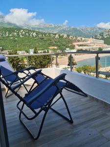 a blue chair on a balcony with a view of the ocean at Apartments Zec in Čanj