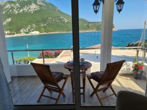 a balcony with a table and chairs and the ocean at Apartments Zec in Čanj