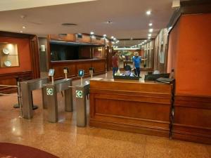 a man sitting at a reception desk in a lobby at BsAs Platino Apart in Buenos Aires