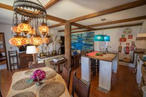 a kitchen and dining room with chandeliers at Beach House Babylon guest house with kitchenette and garden in Torreira