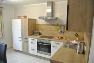a kitchen with a white refrigerator and a sink at Ferienhaus Stricker in Ehrwald