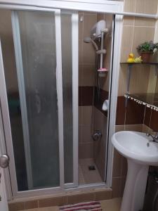 a shower with a glass door in a bathroom at Studio Apartment at Baguio City in Baguio