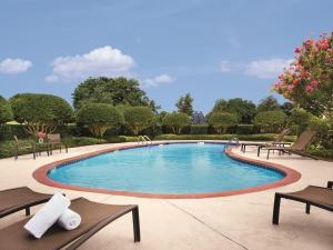 a large swimming pool with benches and trees at Ameristar Casino Hotel Vicksburg, Ms. in Vicksburg