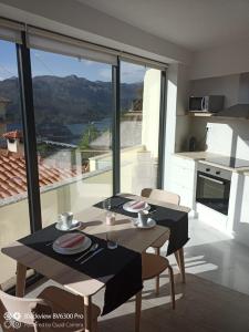 a table and chairs in a kitchen with a large window at Sabeni House in Vieira do Minho