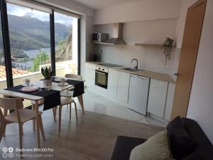 a kitchen with a table and a kitchen with a view at Sabeni House in Vieira do Minho