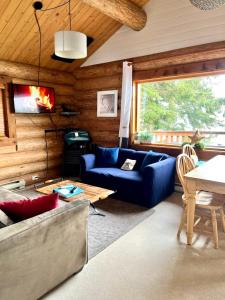 uma sala de estar com um sofá azul e uma mesa em The Beach House Texada - Waterfront Cabin em Gillies Bay