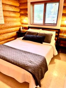 a bedroom with two beds in front of a log wall at The Beach House Texada - Waterfront Cabin in Gillies Bay