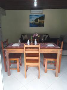 un tavolo in legno con due sedie e un tavolo con fiori di Vista Verde a Morro de São Paulo